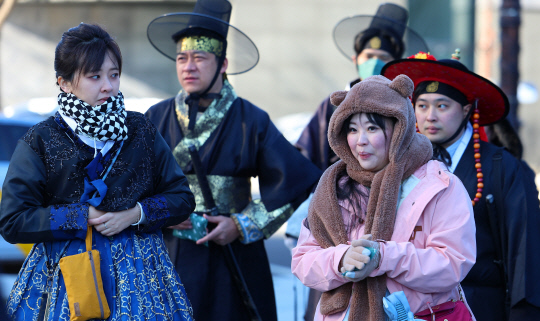 서울 지역 아침 기온이 영하 12도를 기록하는 등 올겨울 들어 가장 추운 날씨를 기록한 17일 오전 서울 경복궁 인근에서 두꺼운 옷차림의 관광객들이 길을 지나고 있다.   [연합뉴스]